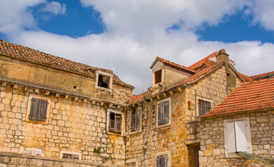 Historic stone houses on the waterfront of Milna Village on the west coast of Brac Island in Croatia. The bell tower of the Church of Our Lady of the Annunciation is centre