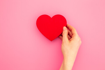 Red heart with woman hands, top view. Health care and love concept
