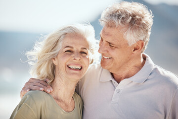 Senior couple, laughing and outdoor at beach with happiness, freedom and care on vacation. Face of...