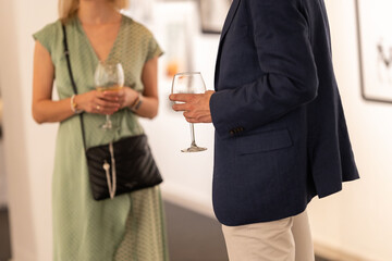 Successful people holding wine glasses at an art exhibition