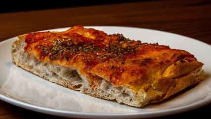 Focaccia is a typical Italian appetizer or snack, which is refined with vegetables, cheese, mortadella, basil or simple spreads and olive oil