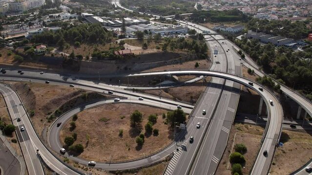 Aerial drone POV tracking of A5 highway and junctions in Cascais, Portugal, heading east towards Carcavelos, Oeiras and Lisbon