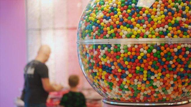 father and son buying sweet candy and bubble gum at sweet store