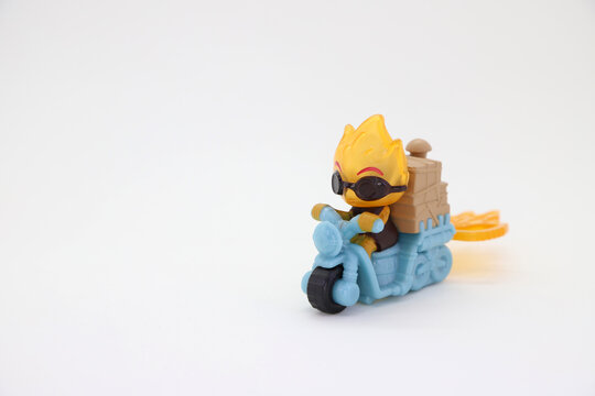 Character from the Disney Pixar movie Elemental. Ember Lumen toy doll riding a motorcycle on white background isolated and with copy space. Representation of fire. 