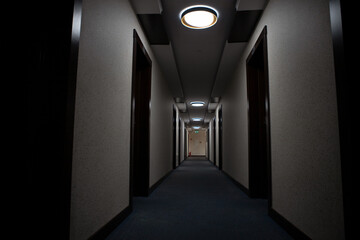 Doors along the dark long corridor of the motel hotel.