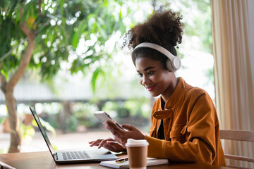 African american businesswoman in headphone using smartphone to listening music after work finished