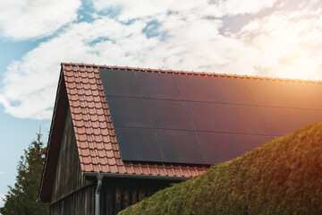 Modern black cells solar panels on the roof of private house. Photovoltaic dotation from European...