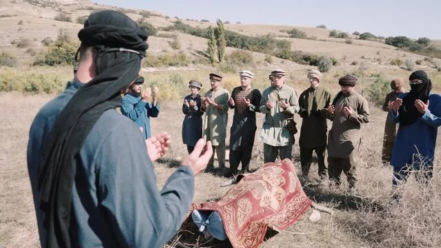 Muslim funerals during the war in Afghanistan. Pashtun men stand.