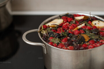 A full pot of hot homemade stewed fruit from various seasonal berries, raspberries, blackberries,...