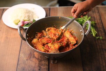 indian fish curry served with rice in a bowl closeup with selective focus and blur