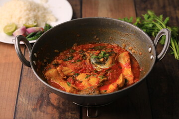 indian fish curry served with rice in a bowl closeup with selective focus and blur