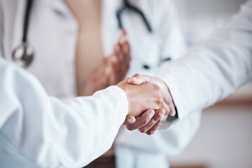 Closeup, teamwork or doctors shaking hands for goal, good job or promotion success in a hospital meeting. Clapping, congratulations or proud healthcare worker with handshake for medical collaboration