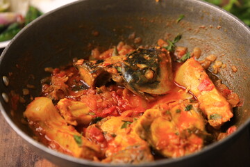 indian fish curry served with rice in a bowl closeup with selective focus and blur