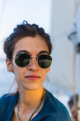 Portrait of a girl in sunglasses sitting on a yacht.