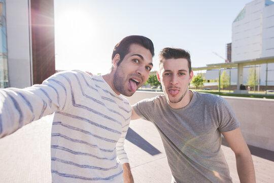 Two multiethnic male best friends outdoors taking selfie