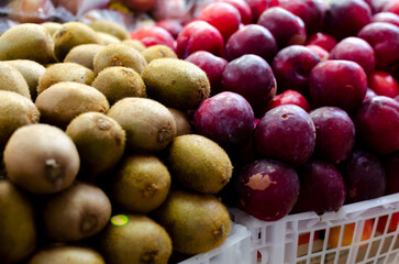 Sapotis and plums stacked on a table for sale. Healthy trade.