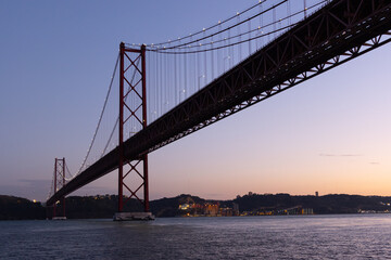 Fototapeta na wymiar highlighted April 25 Bridge over the Tagus river At Sunset