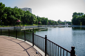 Fototapeta premium A pond with non-working fountains surrounded by a monument of trees and lawn
