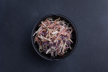 Delicious cabbage salad on a dark background, delivery, close up 