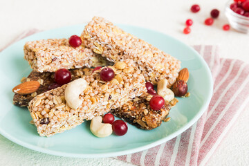 Various granola bars on table background. Cereal granola bars. Superfood breakfast bars with oats, nuts and berries, close up. Superfood concept
