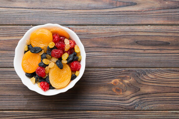 Bowl with different dried fruits on table background, top view. Healthy lifestyle with copy space