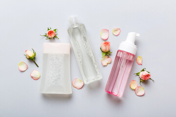 Fancy healthcare bottles for serum, micellar, tonic, toner, lotion, water and cream with rose flower. Natural oranic spa cosmetics concept. Mockup, template, Top view
