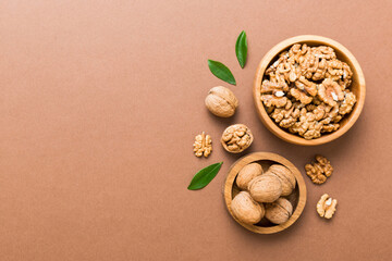 Fototapeta na wymiar Walnut kernel halves, in a wooden bowl. Close-up, from above on colored background. Healthy eating Walnut concept. Super foods with copy space
