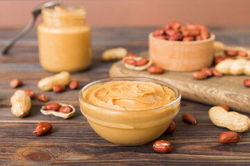 Bowl of peanut butter and peanuts on table background. top view with copy space. Creamy peanut pasta in small bowl