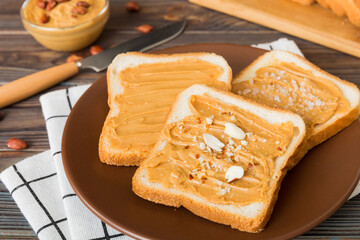 Peanut butter sandwiches or toasts on light table background.Breakfast. Vegetarian food. American cuisine top view vith copy space