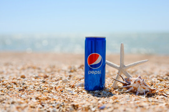 Anapa, Russia - July 30, 2023: Tropical beach with shells and a cold can of Pepsi.
