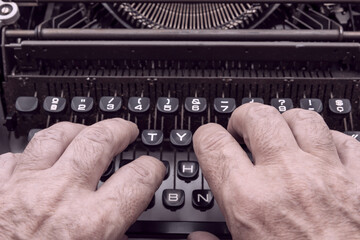 Manos tecleando en una vieja máquina de escribir