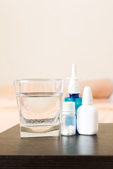 Attractive sick pregnant woman is lying in sofa. Taking pills from colds