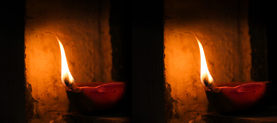 Selective Focus two Traditional diya lamps lit during diwali celebration. Happy Diwali Lit diya lamp on street at night or Diwali diya or clay lamp on wall background