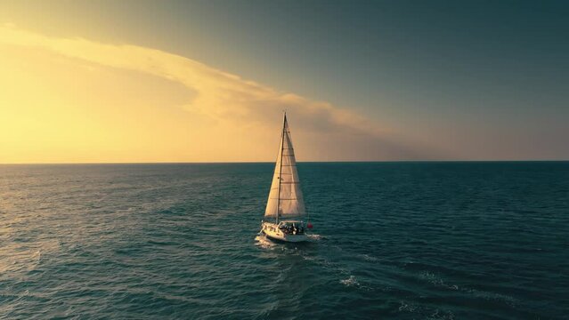 Sailboat on the background of the sunset over the sea