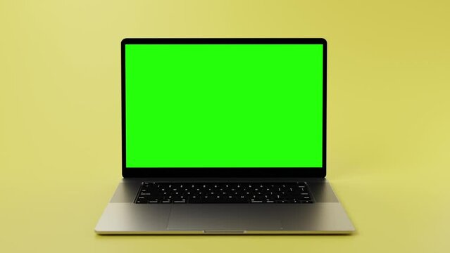 Modern laptop with green screen on display for chromakeying and placing content. Laptop in front of mint yellow background