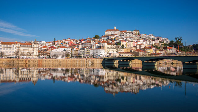 View of the old town of Coimbra reflected in the river, Portugal.