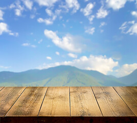 Empty wooden countertop, wooden table, surface. Against the background of nature. Sky with clouds. Spring, summer, autumn background. Landscape. Plants, trees. Mountains. A sunny day. Copy space