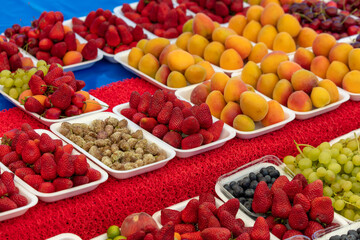 Fresh apricots, strawberries on the counter in the market