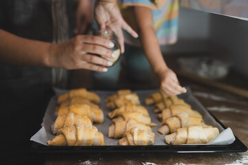 Hands making croissants, in the kitchen preparing for baking 