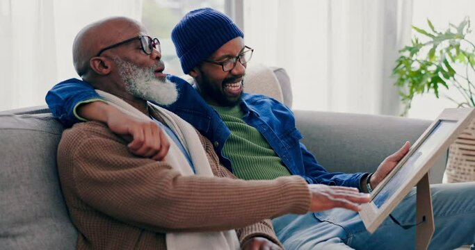 Family, picture frame and a senior father with his son on a sofa in the living room of their home for nostalgia. Smile, laughing and black man with his elderly parent looking at a photograph together