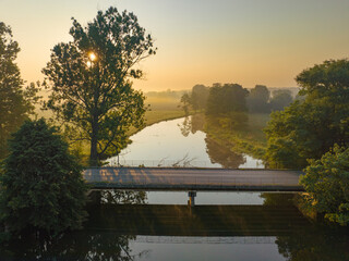 Mglisty poranek nad rzeką o wschodzie słońca  