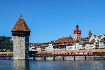 Obraz premium The Kapellbrucke (literally, Chapel Bridge), a covered wooden footbridge spanning the river Reuss diagonally in the city of Lucerne in central Switzerland