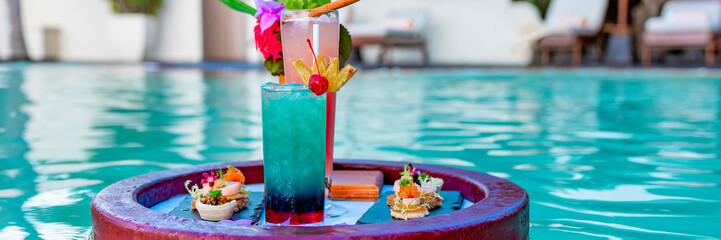 served floating tray in swimming pool with drinks and snacks on tropical island resort in Maldives, cocktails and canapes for romantic date or honeymoon in luxury hotel, travel concept