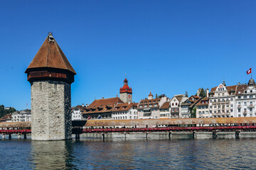 Obraz premium The Kapellbrucke (literally, Chapel Bridge), a covered wooden footbridge spanning the river Reuss diagonally in the city of Lucerne in central Switzerland