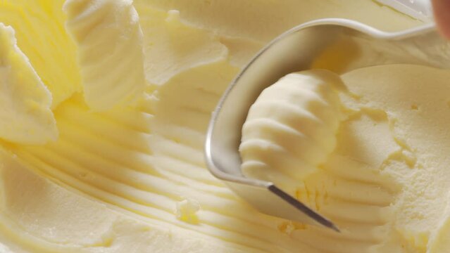 Butter is scraped off with a special butter knife from a pack of butter into a recognizable shape.