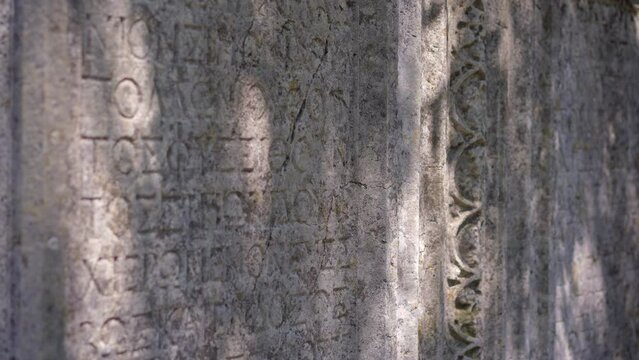 Carved building parts covered with greek letters in the breathtaking ruins of Termessos, nestled within the mountains near Antalya, Turkey