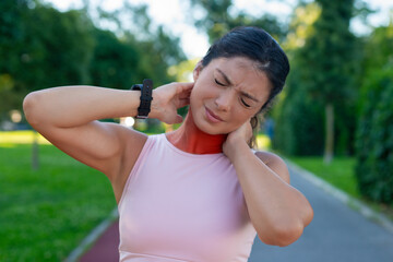 Young fitness woman holding her sports injury neck, muscle painful during training