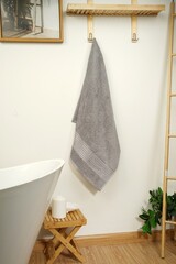 a towel hanging on a wall next to a bathtub towels on wooden in bathroom decor and Spac