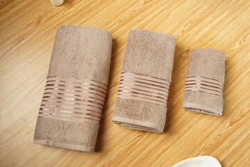 a stack of folded towels on a wooden shelf with a ladder in the background towels on wooden in bath