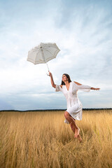Young woman with dress jumps on meadow